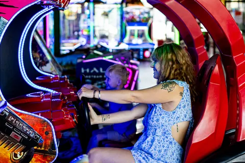 Woman and child playing an arcade racing game