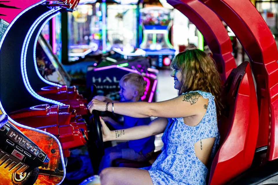 Woman and child playing an arcade racing game