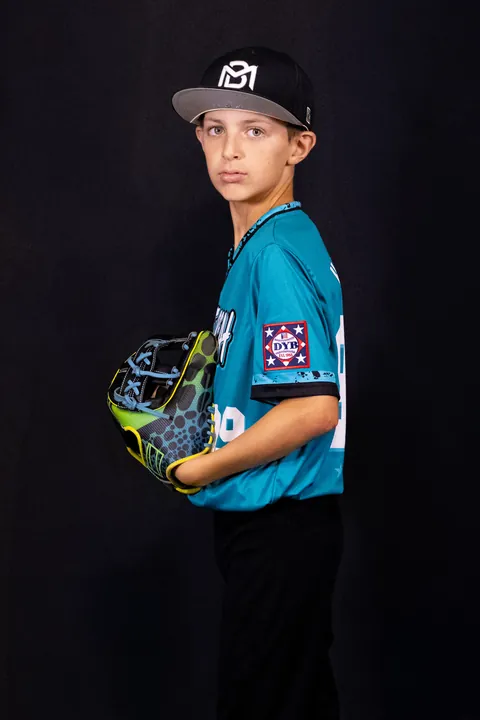 Young baseball player in profile holding his glove