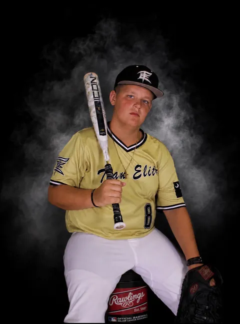 Baseball player holding a bat against a smoky backdrop