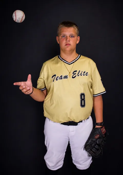 Baseball player tossing a ball in a studio portrait