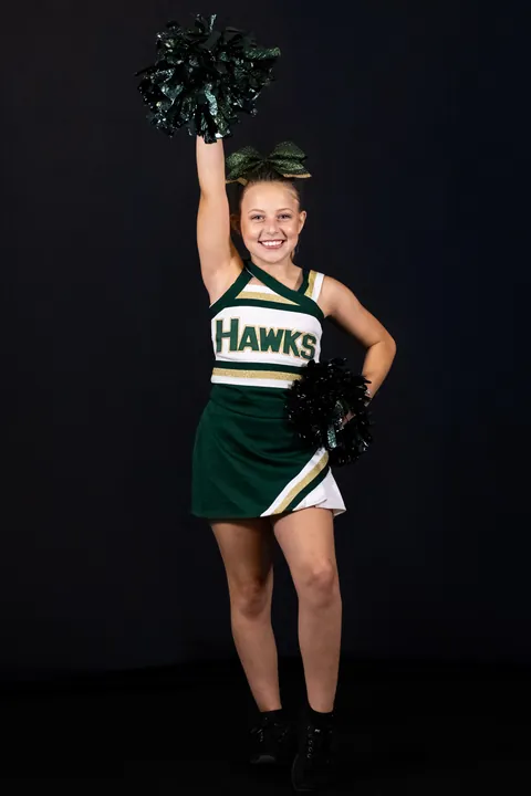 Cheerleader raising a pom-pom overhead