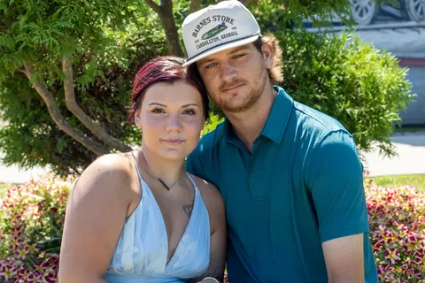 Couple posing close together in a garden