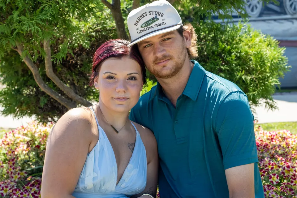 Couple posing close together in a garden