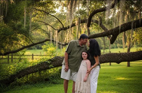 Family embracing beneath a moss-draped live oak
