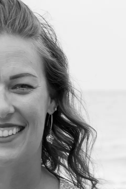 Black and white half-face portrait of a smiling woman