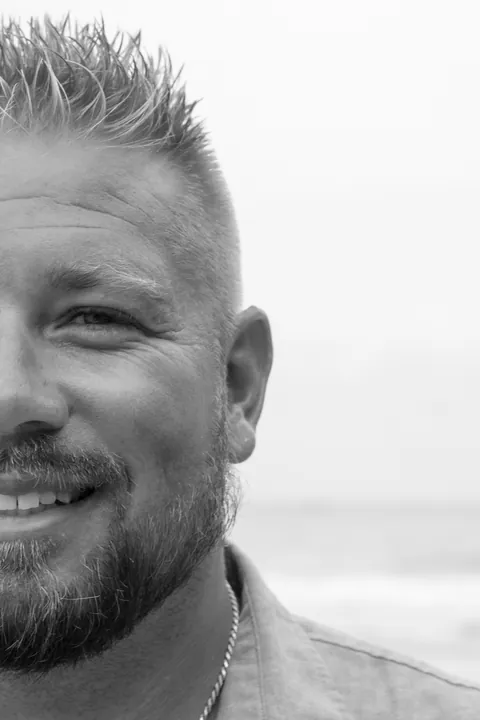 Black and white half-face portrait of a smiling man