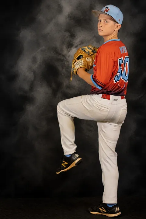 Young pitcher in his windup against a smoky backdrop