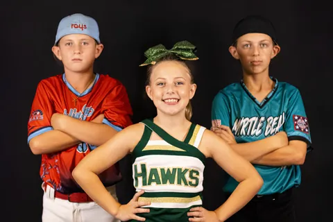Two baseball players and a cheerleader posing together